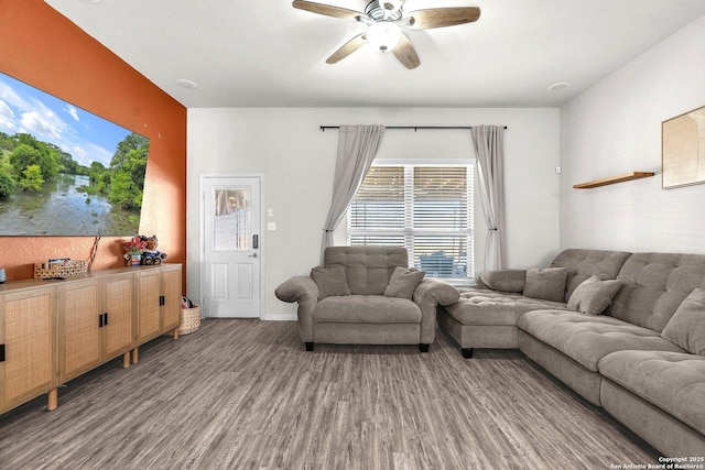 living room with baseboards, wood finished floors, and a ceiling fan