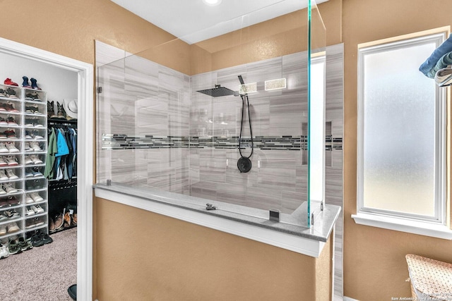 bathroom featuring walk in shower and a spacious closet