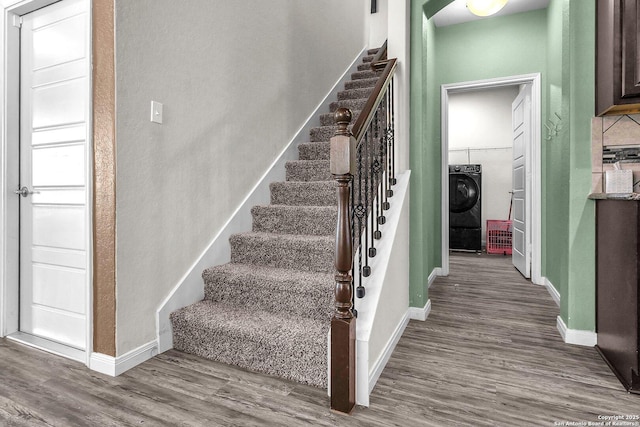 staircase with washer / dryer, baseboards, and wood finished floors