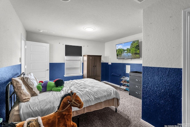 carpeted bedroom featuring a textured ceiling and a textured wall