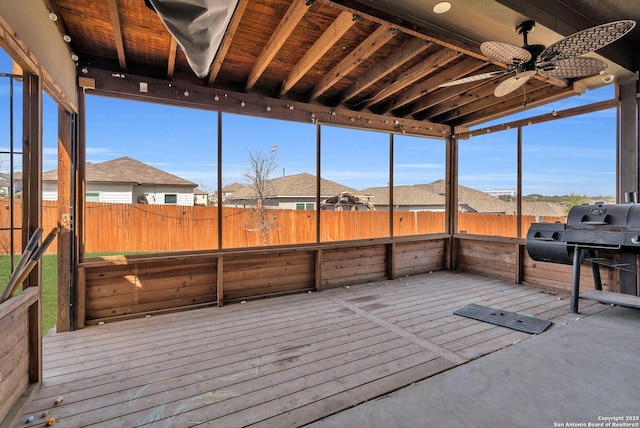 unfurnished sunroom with ceiling fan