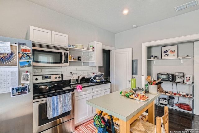 kitchen with visible vents, open shelves, tasteful backsplash, white cabinetry, and stainless steel appliances