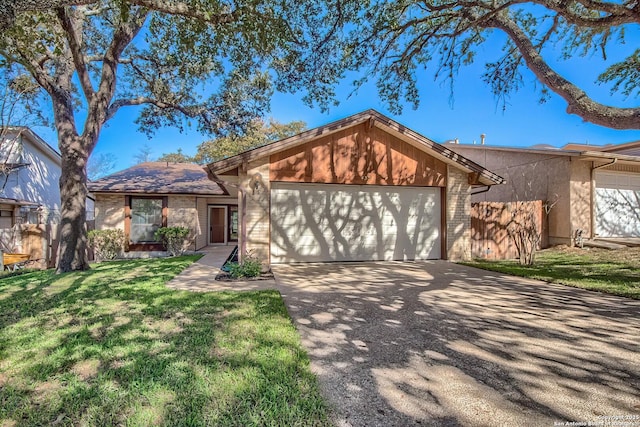 view of front of home with brick siding, fence, concrete driveway, a front yard, and an attached garage