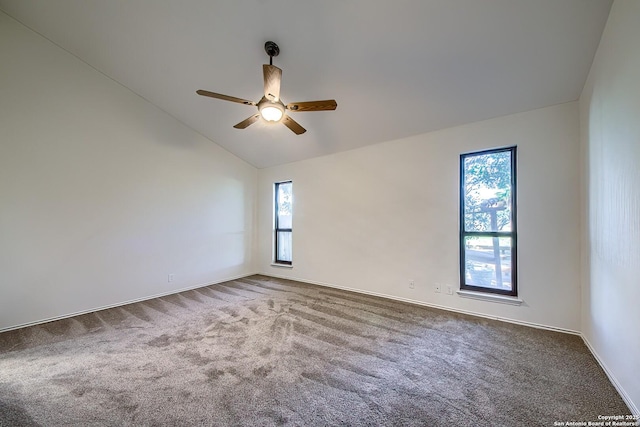 carpeted empty room featuring vaulted ceiling and ceiling fan