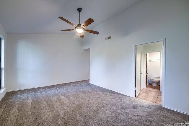 carpeted empty room featuring high vaulted ceiling, visible vents, and ceiling fan