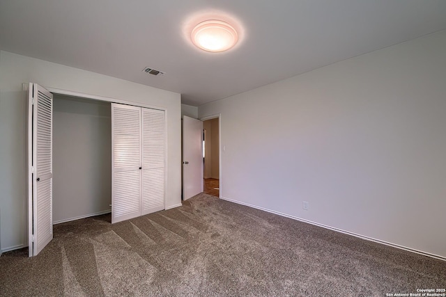 unfurnished bedroom with visible vents, carpet, and a closet