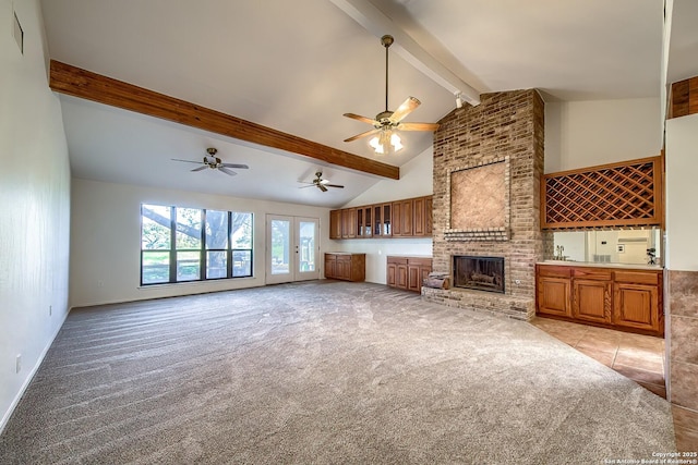 unfurnished living room with beamed ceiling, high vaulted ceiling, wet bar, light carpet, and a brick fireplace