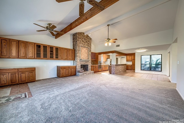 unfurnished living room featuring light carpet, a fireplace, high vaulted ceiling, and a ceiling fan