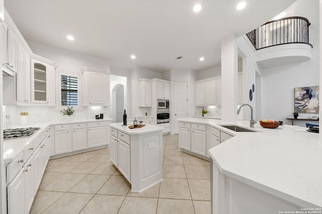 kitchen with light tile patterned floors, recessed lighting, a sink, appliances with stainless steel finishes, and tasteful backsplash