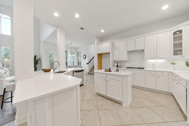 kitchen featuring gas cooktop, visible vents, a sink, dishwasher, and tasteful backsplash