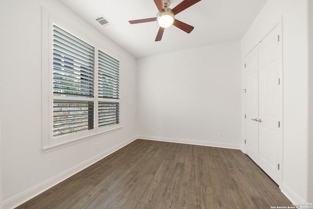 unfurnished bedroom with visible vents, baseboards, a closet, and dark wood finished floors