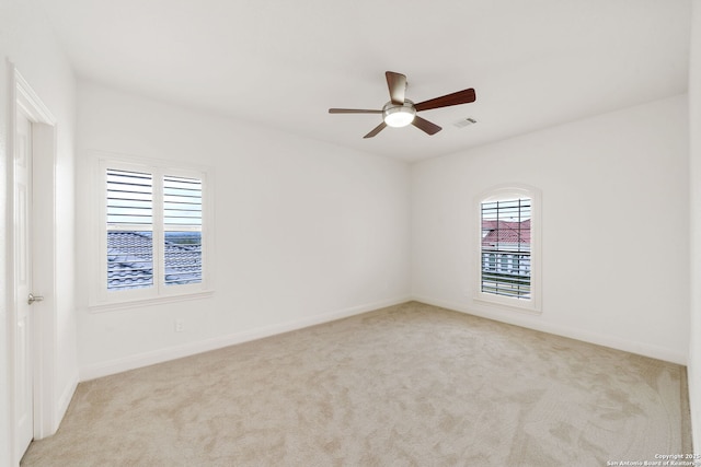 spare room with a ceiling fan, carpet, visible vents, and baseboards