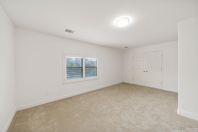 spare room with visible vents, baseboards, and carpet