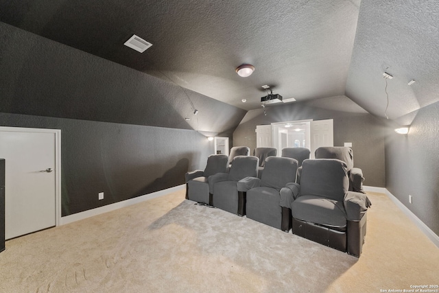 cinema room featuring visible vents, lofted ceiling, a textured ceiling, and carpet flooring