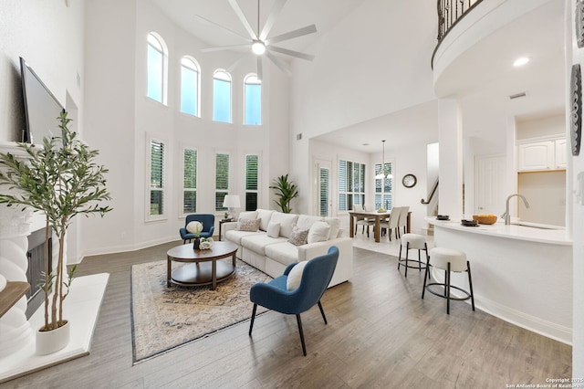 living area featuring an inviting chandelier, wood finished floors, and baseboards