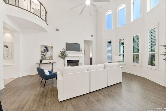 living room with a fireplace, wood finished floors, and baseboards