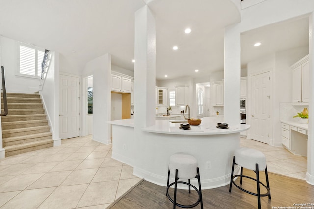 kitchen featuring a spacious island, white cabinetry, recessed lighting, light countertops, and light tile patterned floors