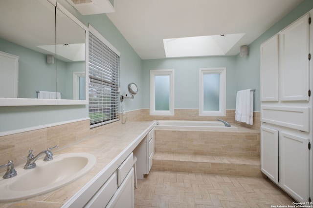 full bathroom with a skylight, vanity, and a bath