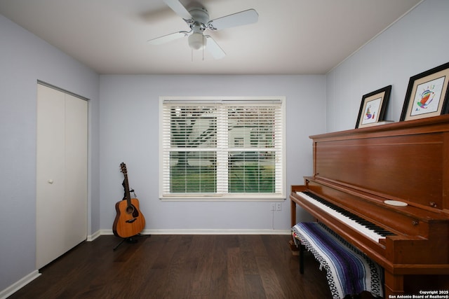 interior space with baseboards, wood finished floors, and a ceiling fan