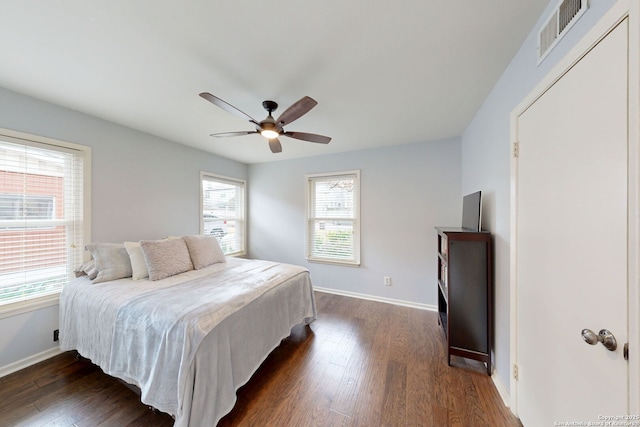 bedroom with ceiling fan, dark wood-style floors, visible vents, and baseboards