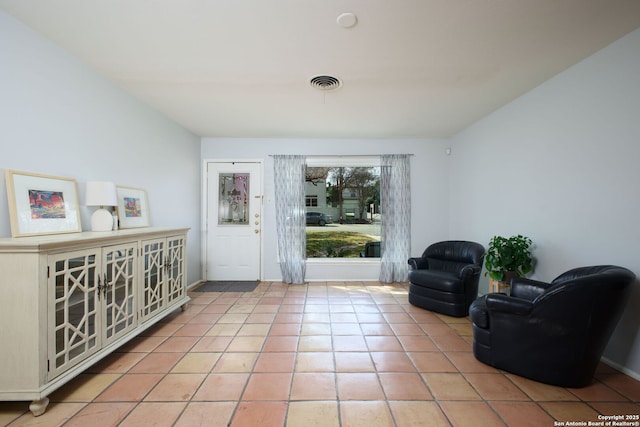 sitting room featuring light tile patterned floors, visible vents, and baseboards