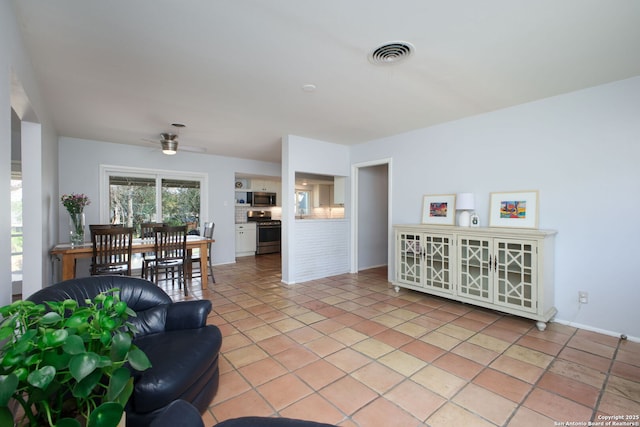 living room featuring light tile patterned floors, visible vents, and a ceiling fan