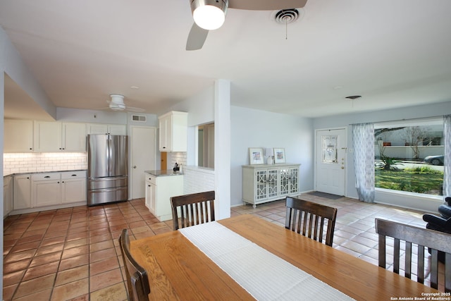 dining area with light tile patterned floors, a ceiling fan, and visible vents