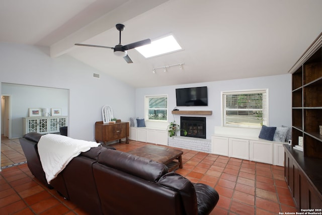 living area featuring visible vents, lofted ceiling with skylight, plenty of natural light, and a fireplace