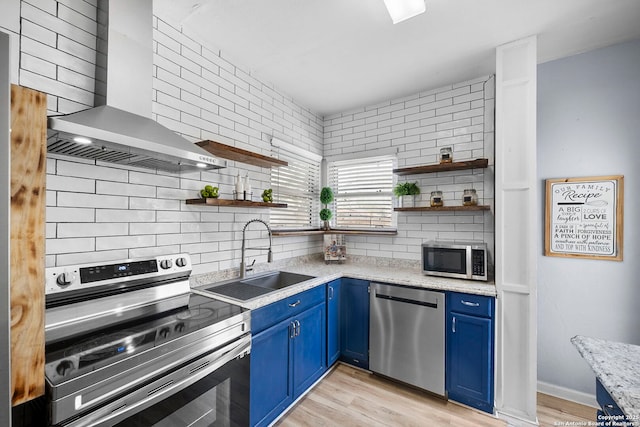 kitchen featuring blue cabinets, open shelves, appliances with stainless steel finishes, and a sink