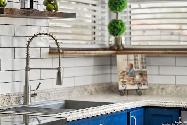 kitchen featuring blue cabinetry, light countertops, and a sink