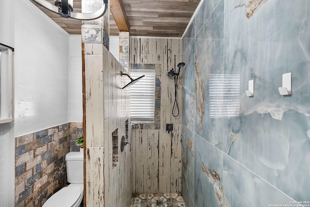 bathroom with wood ceiling, toilet, tile walls, and a tile shower