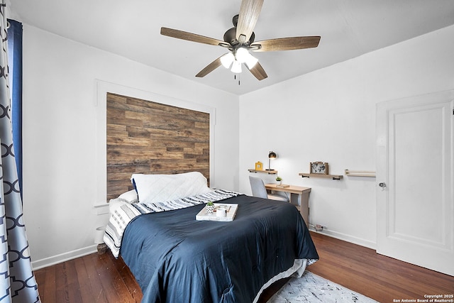 bedroom featuring a ceiling fan, wood finished floors, and baseboards