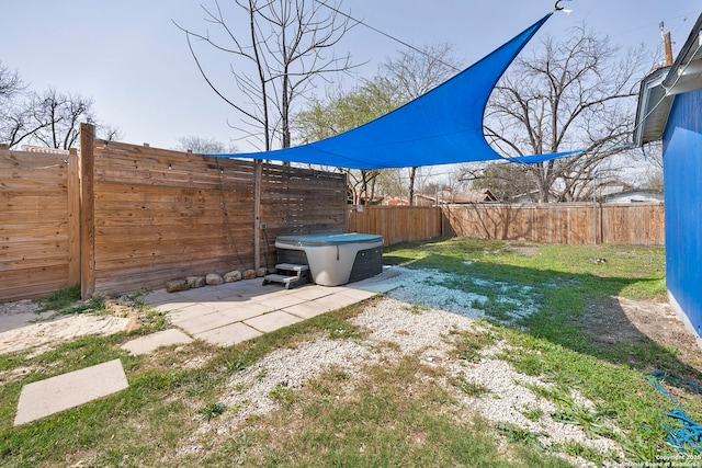 view of yard with a patio area, a fenced backyard, and a hot tub