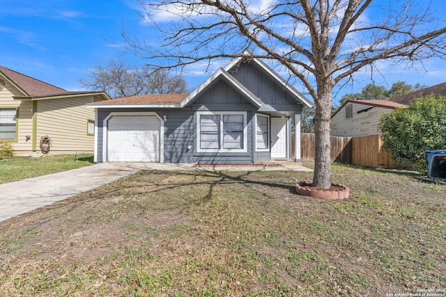 view of front of house with a front yard, fence, driveway, an attached garage, and board and batten siding