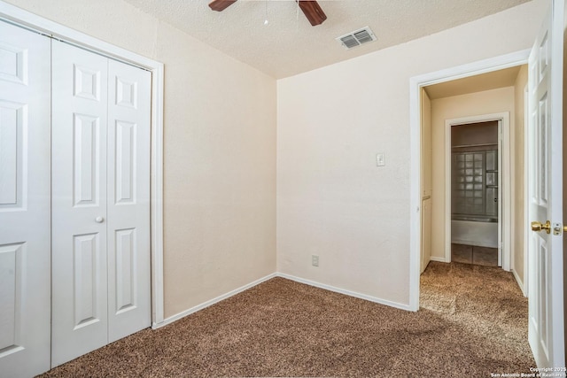 unfurnished bedroom featuring carpet flooring, visible vents, a closet, and a textured ceiling