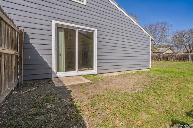 view of side of property with a lawn and fence