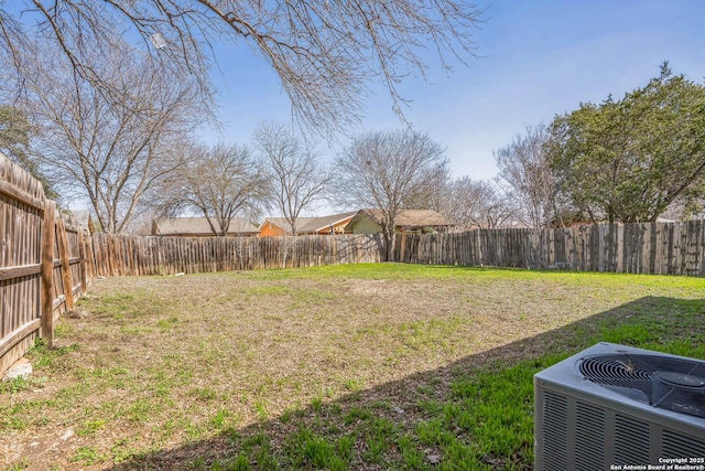 view of yard with central air condition unit and a fenced backyard