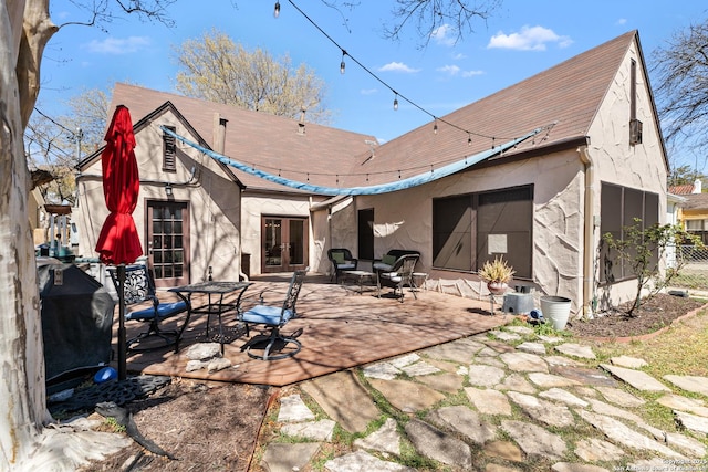 rear view of property with stucco siding, french doors, and a patio