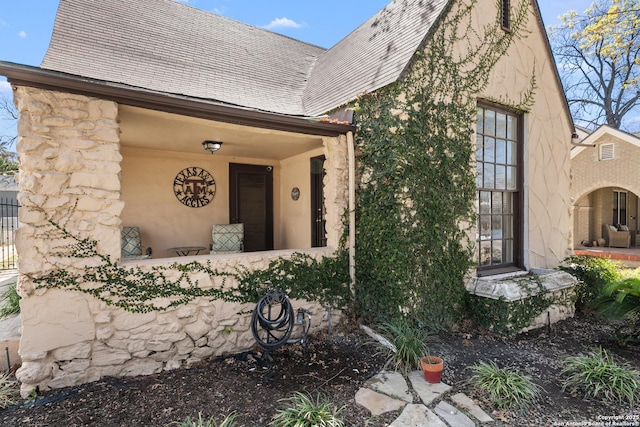 view of front of home featuring stucco siding and a shingled roof