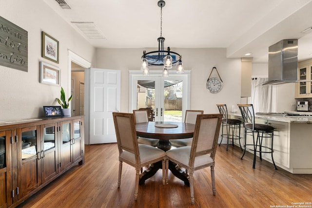 dining room featuring light wood-type flooring, an inviting chandelier, and visible vents