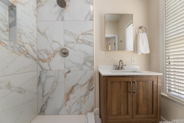 full bath featuring a marble finish shower and vanity