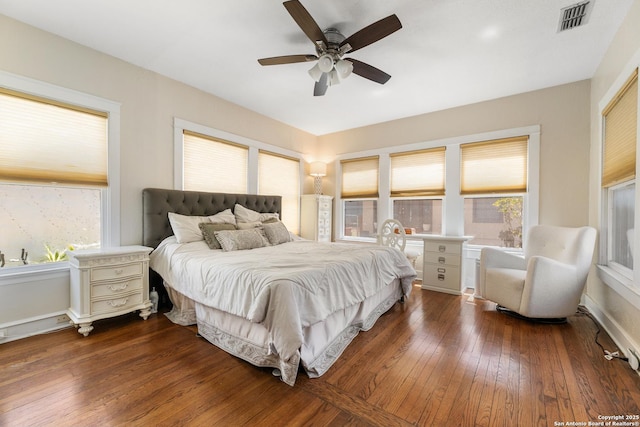 bedroom with visible vents, baseboards, dark wood-style floors, and a ceiling fan