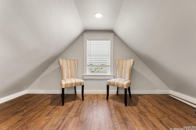 sitting room featuring lofted ceiling, baseboards, and hardwood / wood-style flooring