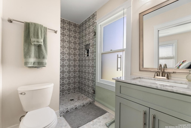 full bathroom with vanity, toilet, and a tile shower