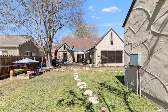 back of house with fence, a lawn, and a patio area