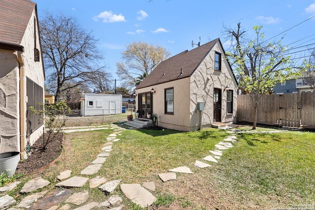 back of property featuring a lawn, entry steps, fence private yard, and roof with shingles