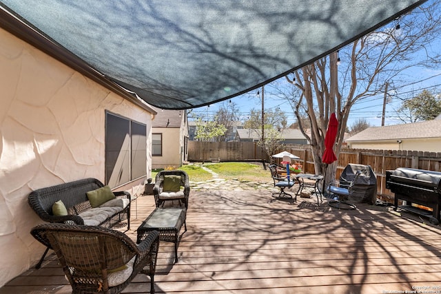 wooden terrace featuring area for grilling, a fenced backyard, and an outdoor hangout area