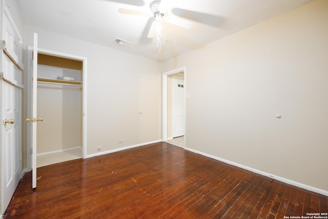 unfurnished bedroom featuring visible vents, baseboards, a closet, and hardwood / wood-style floors