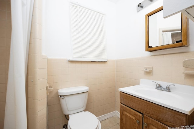 bathroom with vanity, tile patterned flooring, wainscoting, tile walls, and toilet