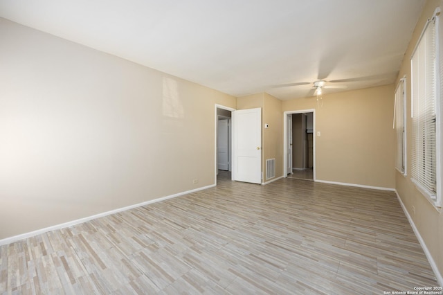 empty room with ceiling fan, visible vents, baseboards, and light wood-style flooring